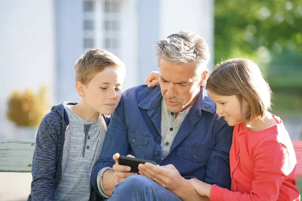 Padre con bambini seduti sulla panchina — Foto Stock