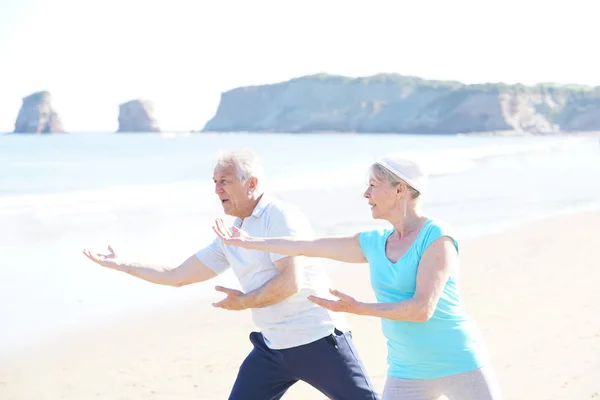 Casal sênior fazendo exercícios de alongamento — Fotografia de Stock