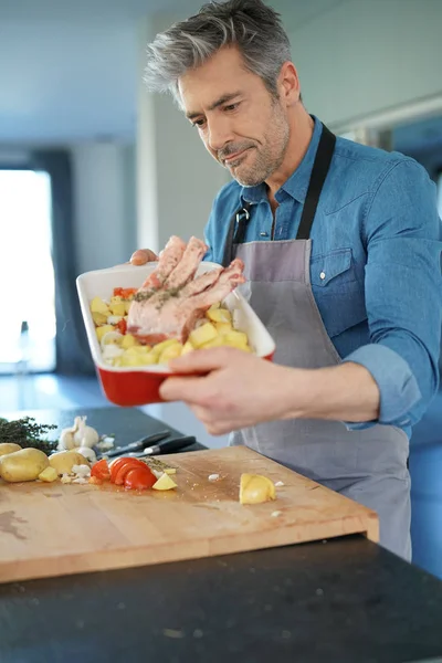 man in kitchen cooking dish for dinner