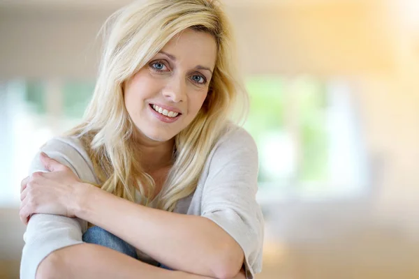 Woman with blue eyes sitting on table — Stock Photo, Image