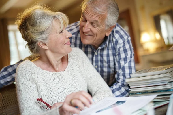 Senior couple sitting at desk — Stock Photo, Image