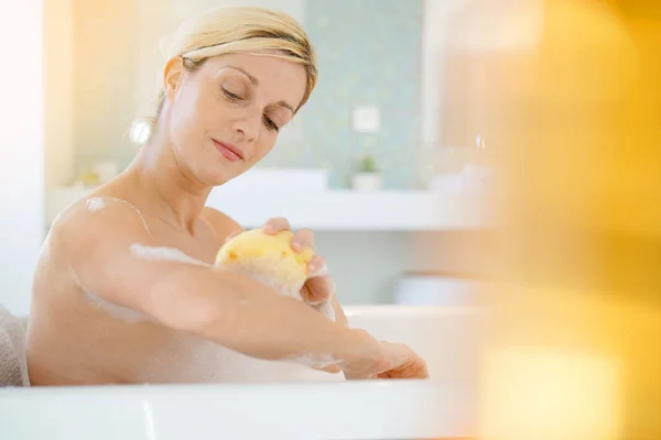 Mulher usando esponja de banho — Fotografia de Stock