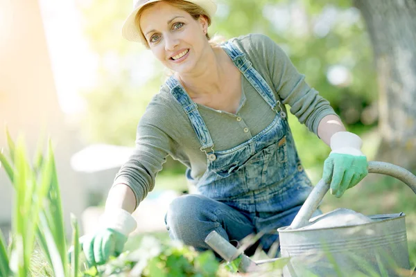 Mujer con sombrero jardinería en el trabajo —  Fotos de Stock