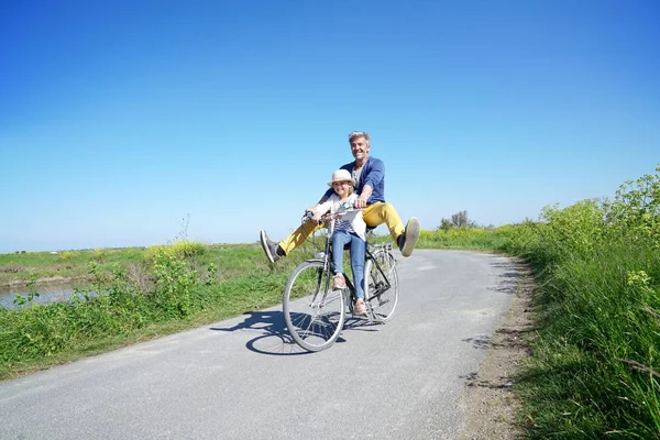 Father and daughter  riding bike together