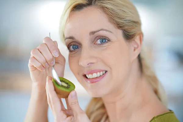 Donna bionda che mangia kiwi — Foto Stock