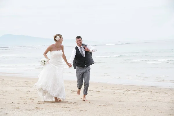 Casal correndo em uma praia de areia — Fotografia de Stock
