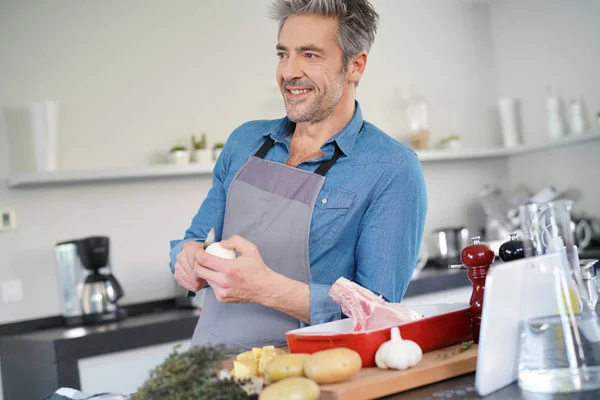 Чоловік на кухні готує тарілку на вечерю — стокове фото