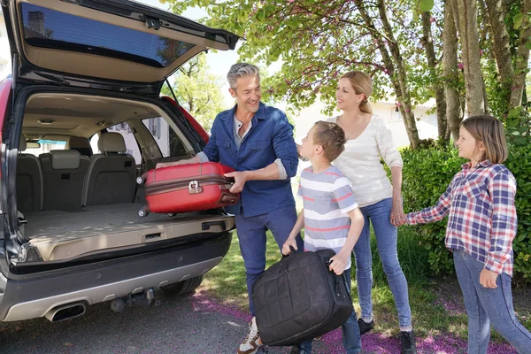 Happy family loading luggage — Stock Photo, Image