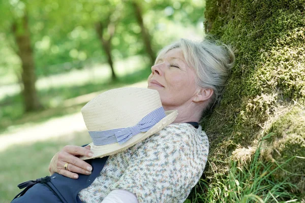 Старша жінка розслабляється в саду — стокове фото