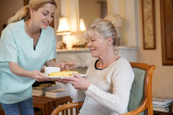 Sjuksköterska föra frukost — Stockfoto