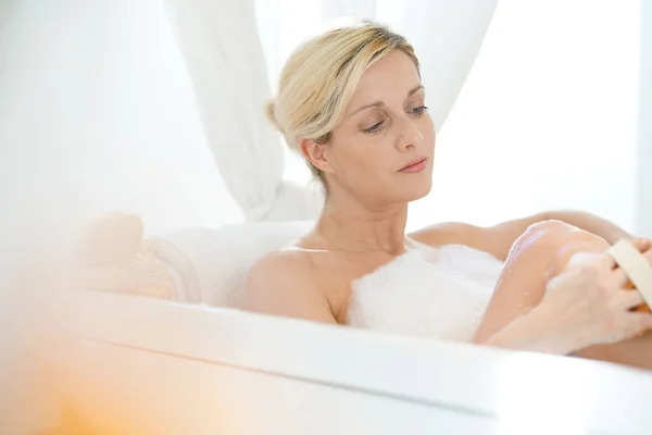 Frau in Badewanne massiert ihre Beine — Stockfoto