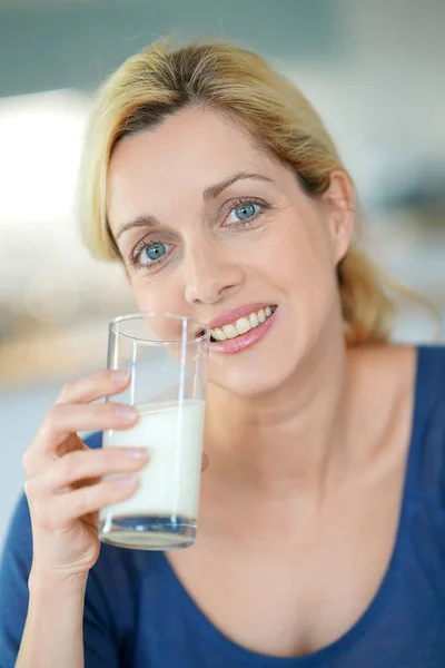 ガラスの牛乳を飲む女性は — ストック写真