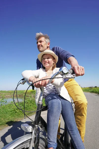 Отец и дочь едут на велосипеде вместе — стоковое фото