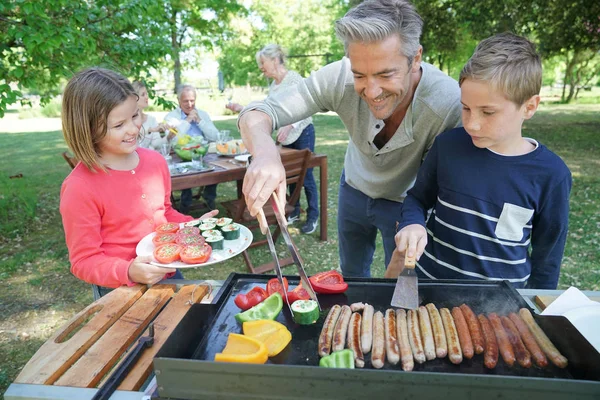 Far med barn förbereder grill — Stockfoto