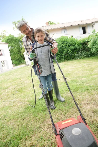 Father and son mowing lawn — Stock Photo, Image