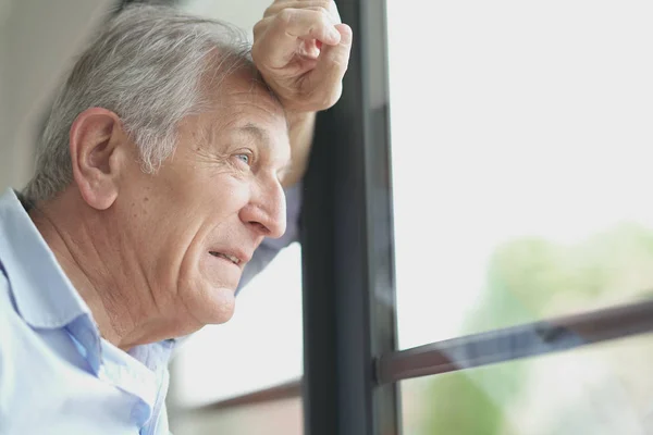 Man op zoek door het venster — Stockfoto