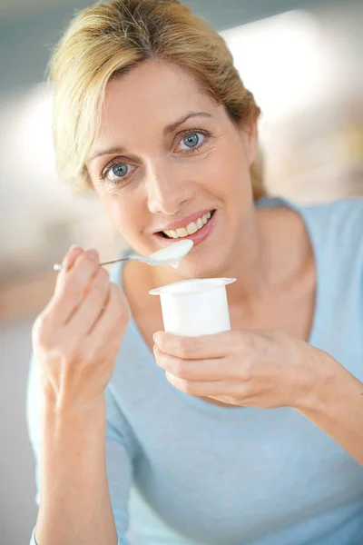 Blonde vrouw eten yoghurt — Stockfoto