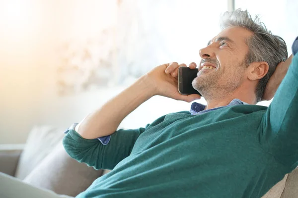 Homme à la maison parlant au téléphone — Photo