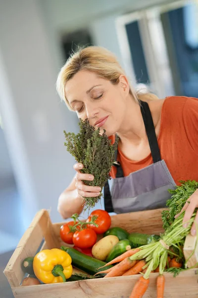 Woman in domestic kitchen holding basket — Stock Photo, Image