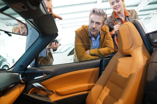 Bil säljaren visar klienter cabrioleter — Stockfoto