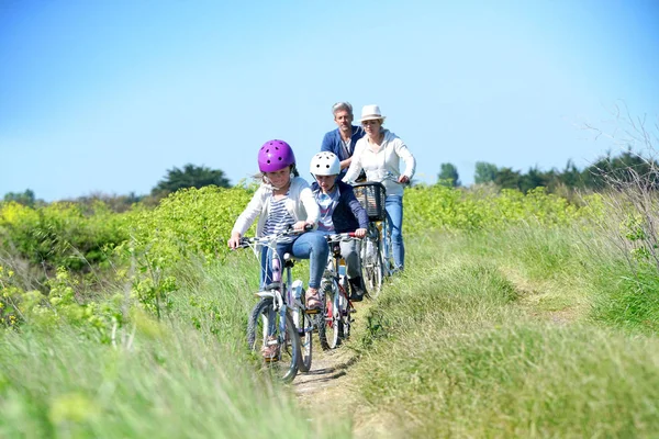 Glad familj ridning cyklar — Stockfoto