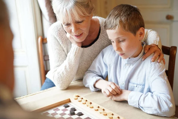 祖父母祖父母与孙子玩跳棋 — 图库照片