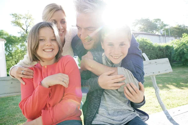 Familia de cuatro sentados en el banco — Foto de Stock