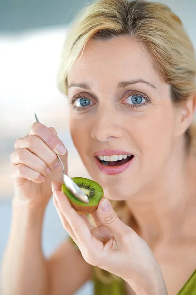 Mujer rubia comiendo kiwi —  Fotos de Stock