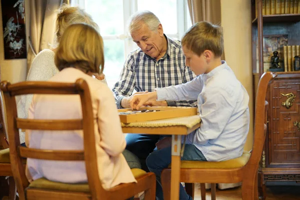 祖父母祖父母与孙子玩跳棋 — 图库照片