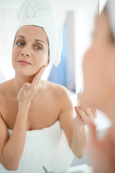 Mujer aplicando crema hidratante —  Fotos de Stock