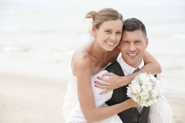 Novio dando piggyback paseo a la novia — Foto de Stock