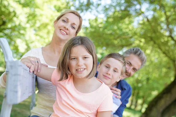 Família feliz sentado no banco — Fotografia de Stock