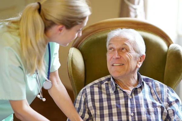 Elderly man looking at nurse — Stock Photo, Image