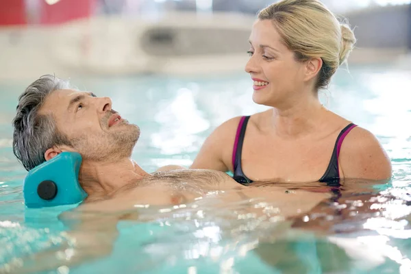 Mann im Wellness-Pool macht Übungen Stockbild