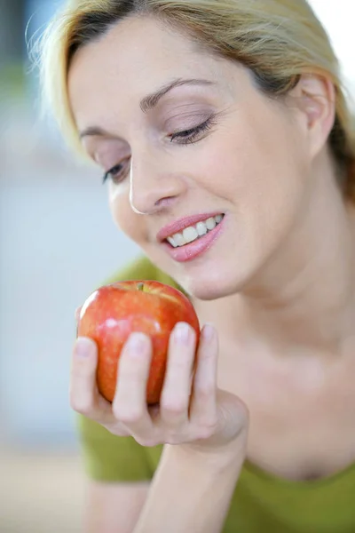 Frau isst einen Apfel lizenzfreie Stockbilder