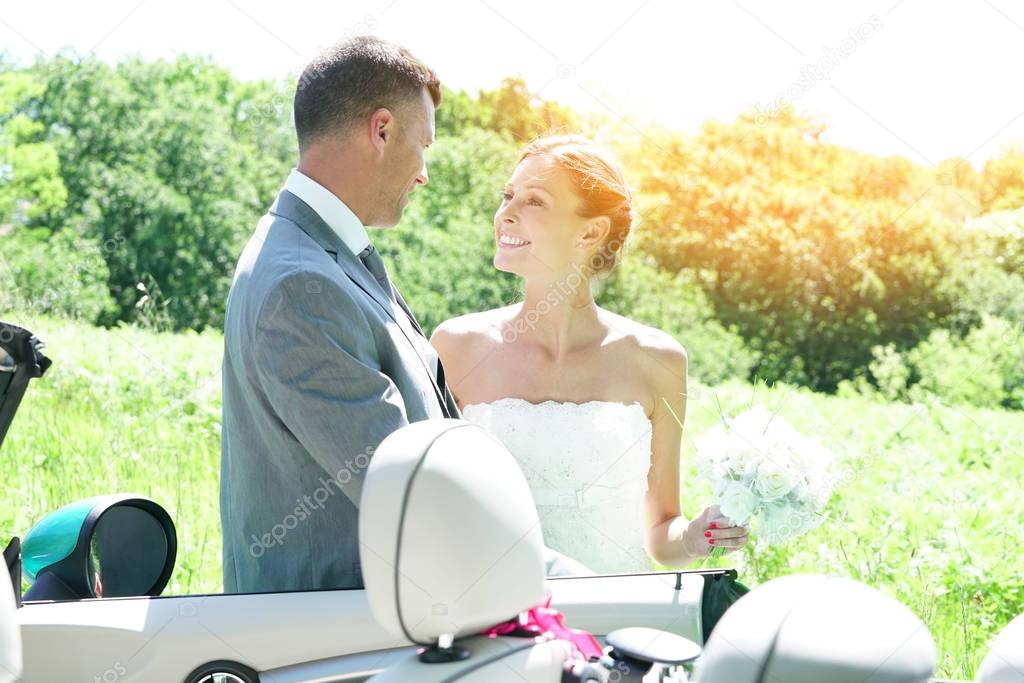 Bride getting in convertible car
