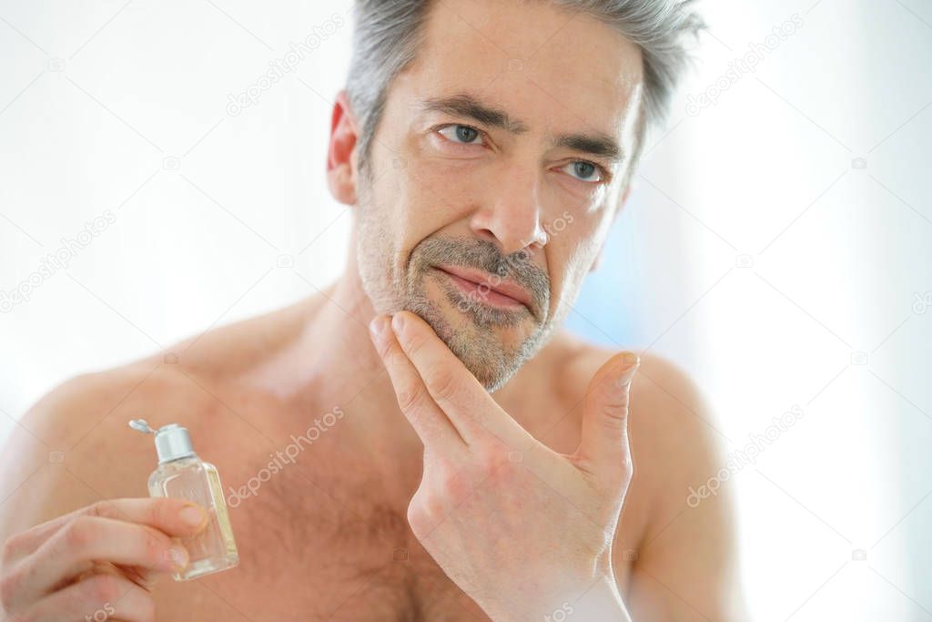 mature man applying facial cream