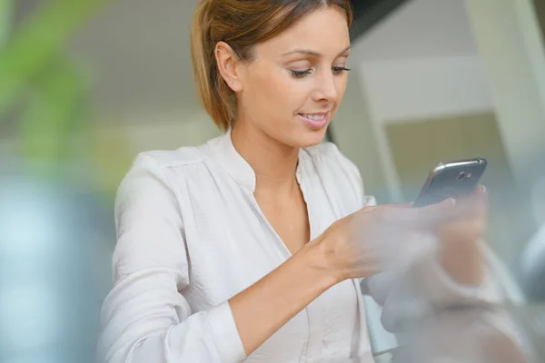 Frau zu Hause mit Smartphone — Stockfoto