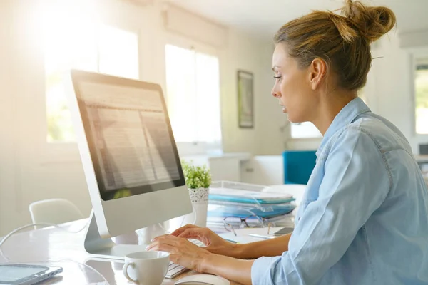 Женщина, работающая на настольном компьютере — стоковое фото