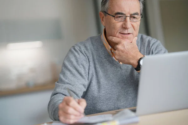 Mann zu Hause mit Laptop verbunden — Stockfoto