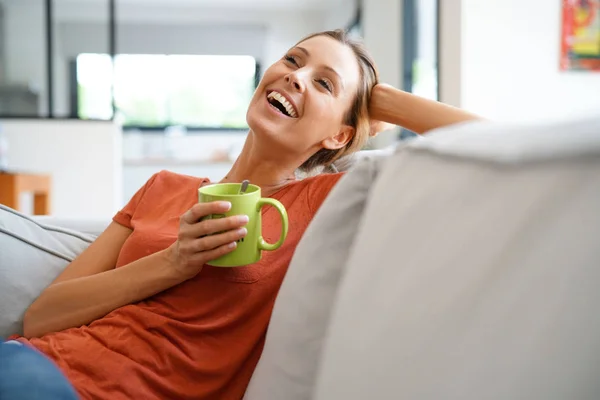 Mujer relajarse en el sofá y beber té — Foto de Stock