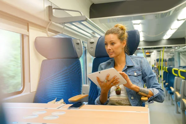 Vrouw in de trein aangesloten op Tablet PC — Stockfoto