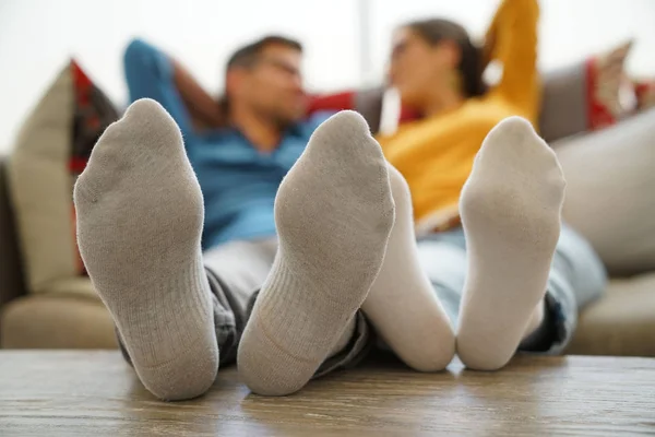 Koppel de voeten op tafel gelegd — Stockfoto