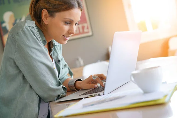 Женщина дома работает на ноутбуке — стоковое фото