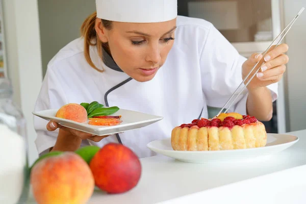 Pastry chef decorating raspberry cake — Stock Photo, Image