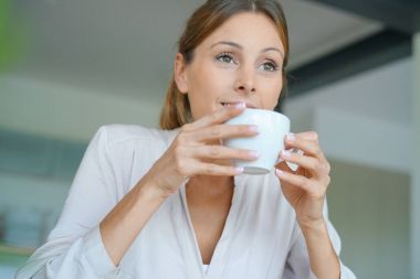 Evde kahve içen kadın.