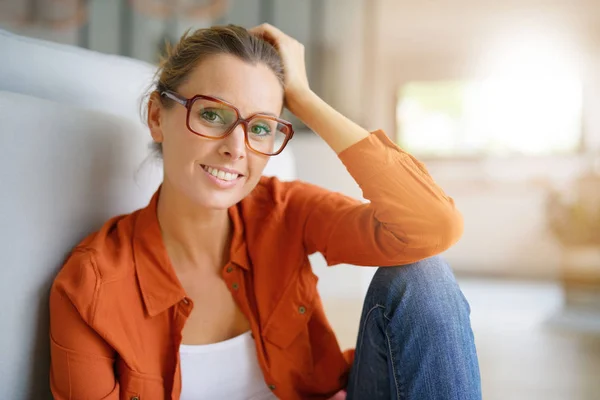 Девушка в модных очках сидит — стоковое фото
