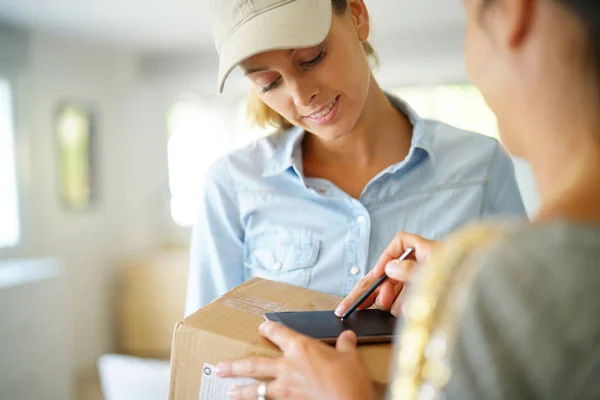 Zustellerin übergibt Paket — Stockfoto