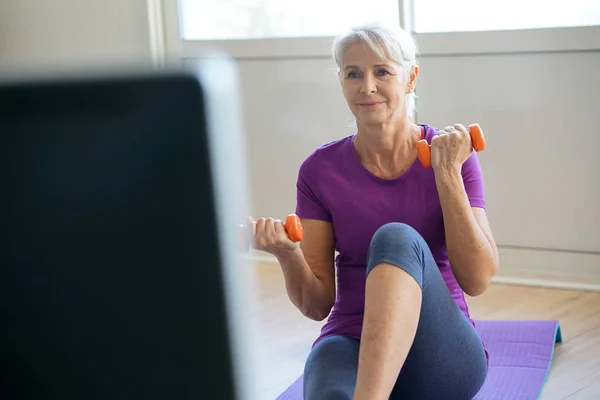 Starší žena, která dělá fitness předvést úkony — Stock fotografie