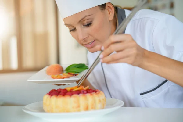 Pastry chef decorating raspberry cake — Stock Photo, Image